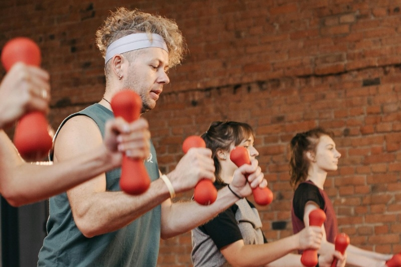 Group of men and women working out with small weights in their hands